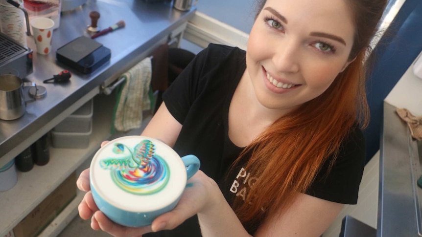 Emily Coumbis holds a Rainbow Coffee