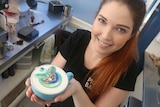 Emily Coumbis holds a Rainbow Coffee