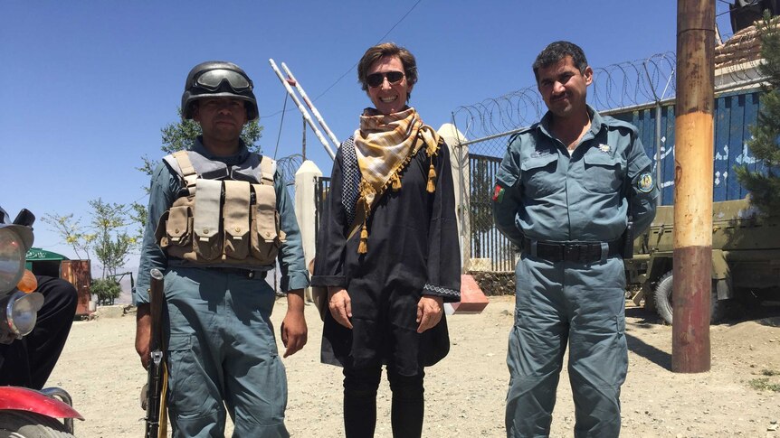 Eddie Ayres stands between two other men in the city of Kabul.