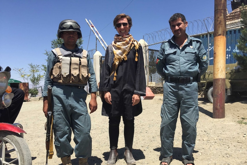 Eddie Ayres stands between two other men in the city of Kabul.