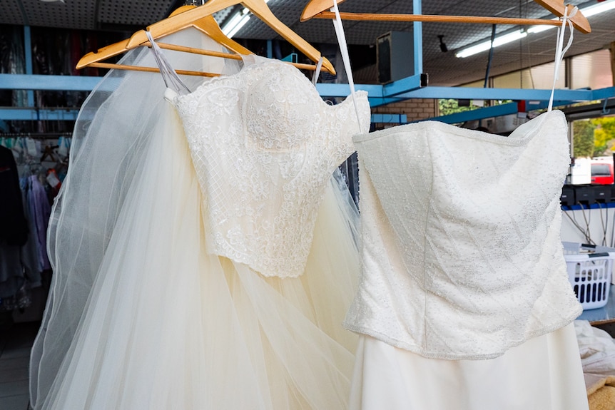 Wedding bridal dresses displayed hanging on coat hangers.