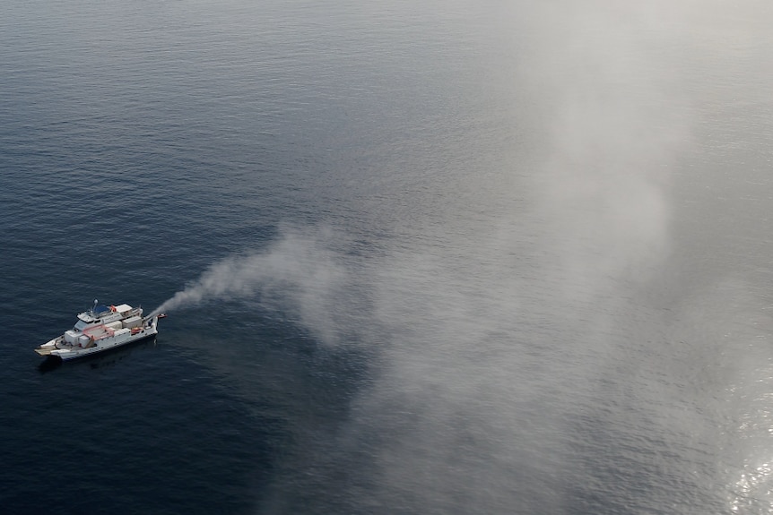 aerial of ship spraying sea water