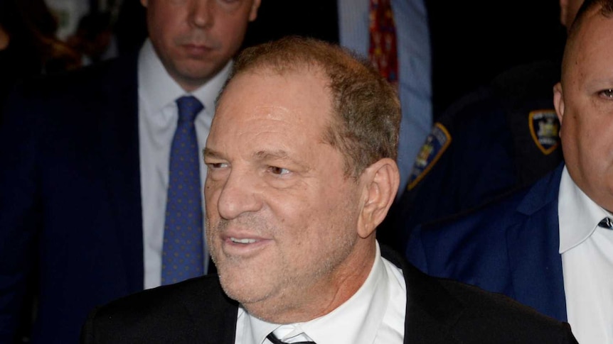 Harvey Weinstein., with his hands behind his back, smiles slightly as he leaves the court.