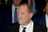 Harvey Weinstein., with his hands behind his back, smiles slightly as he leaves the court.