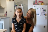 Young daughter Alijana Papas (8) sitting on mother Johanna Papas lap in their kitchen looking into her eyes.