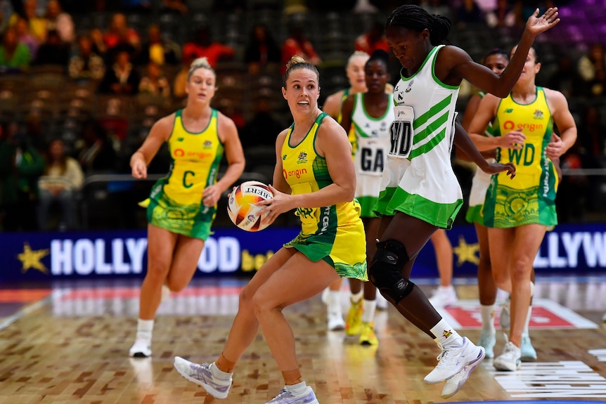 A Diamonds player holds the ball in two hands in the Netball World Cup game against Zimbabwe.