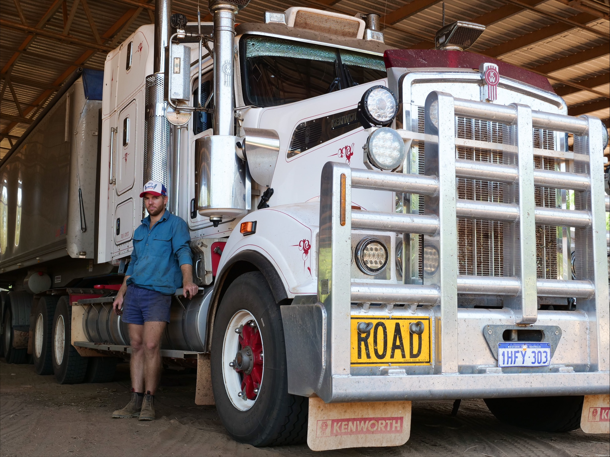 A man standing beside a big truck.