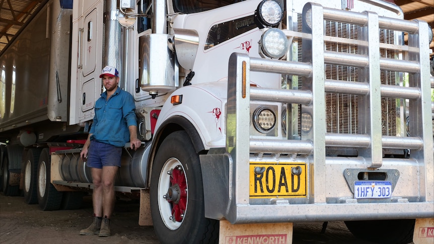 A man standing beside a big truck.