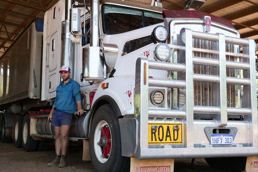 A man standing beside a big truck.