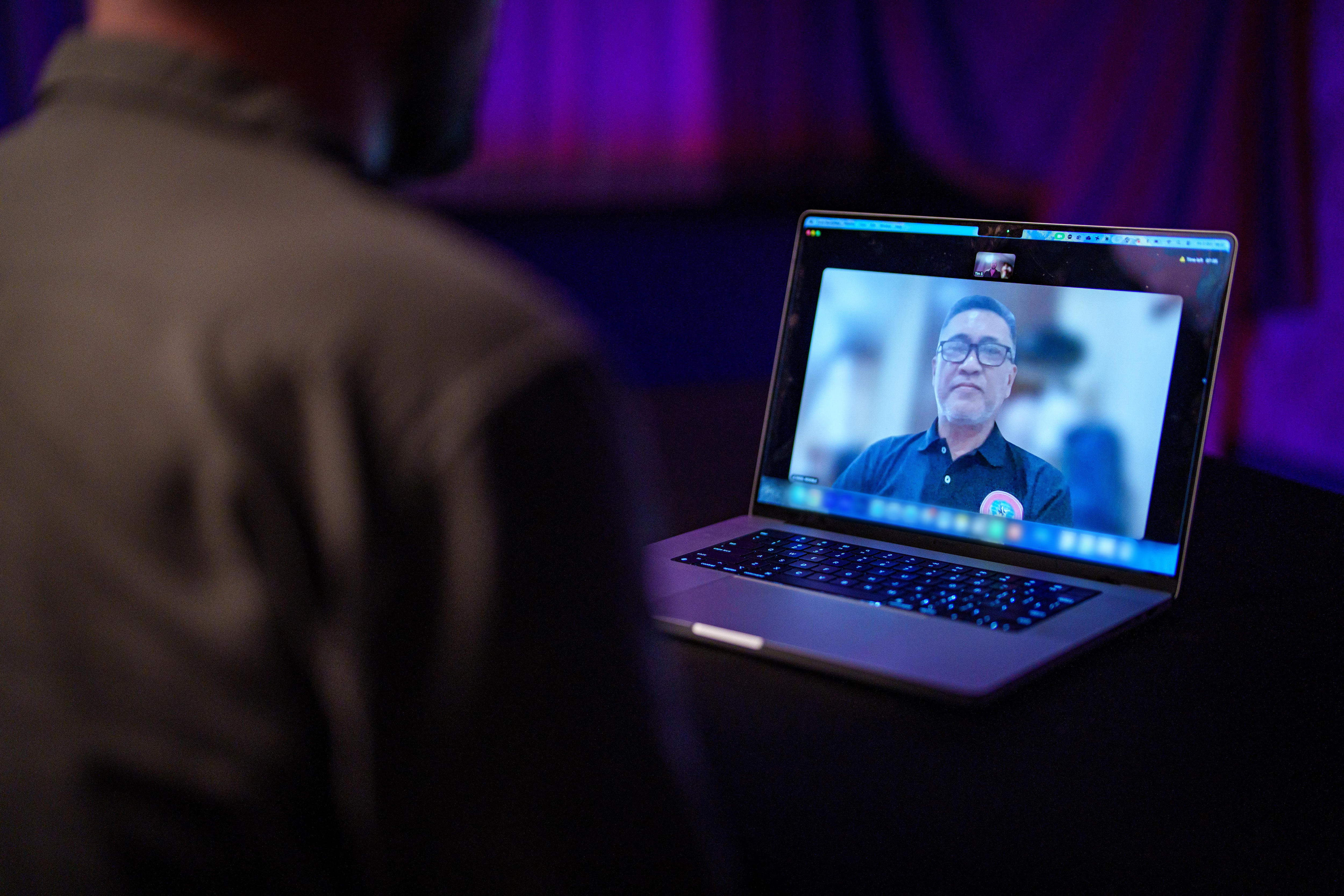 A middle-aged Filipino man is seen on a Zoom call on the screen of an Apple MacBook.