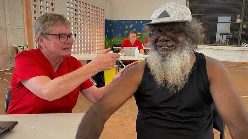 A traditional owner in Maningrida gets his first COVID-19 vaccine from a nurse.
