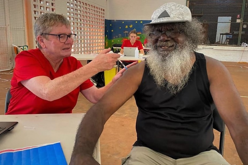 A traditional owner in Maningrida gets his first COVID-19 vaccine from a nurse.