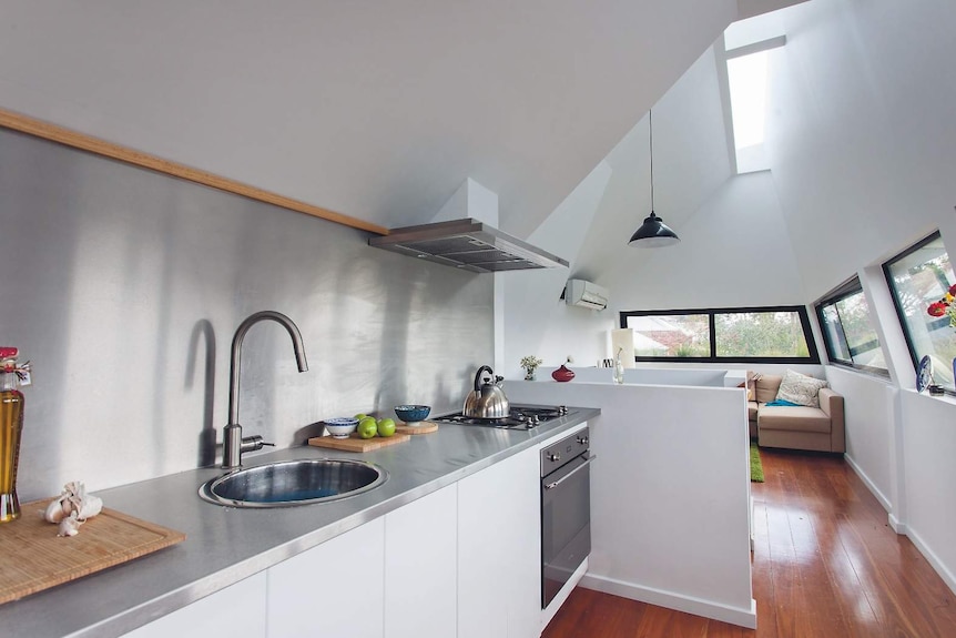 An interior shot showing the combined kitchen and dining area of the grass house.