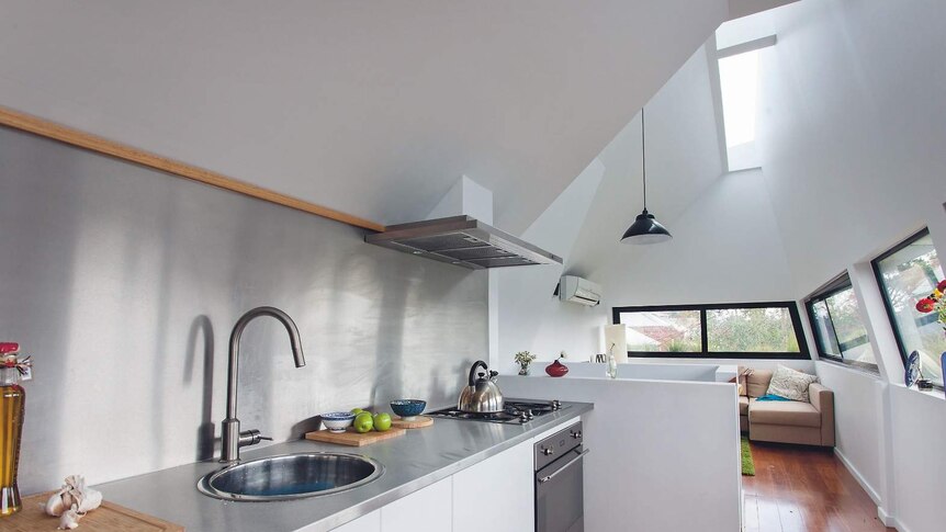 An interior shot showing the combined kitchen and dining area of the grass house.