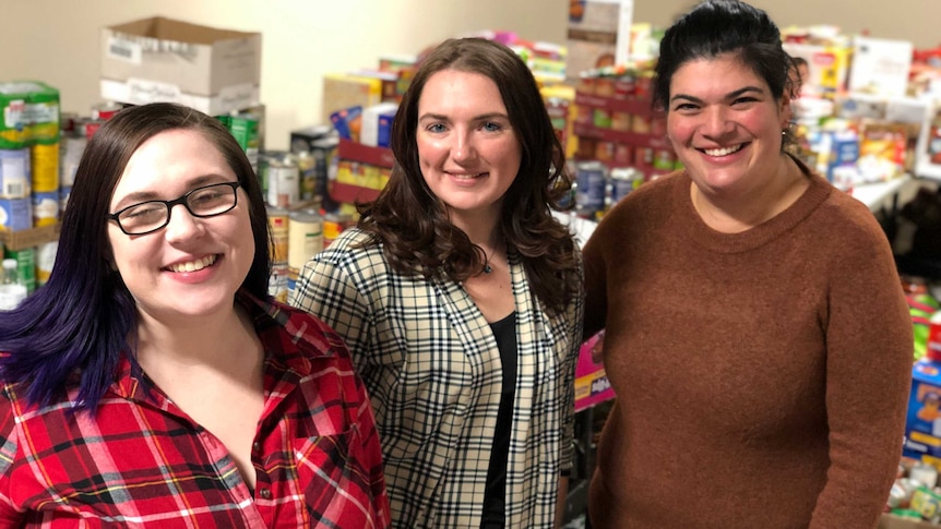 Kayla Scott, Jessica and Tara with food items in crates and on desks