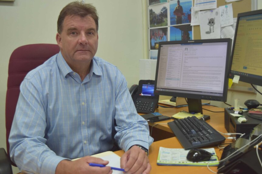 State Member for Burnett Stephen Bennett sits at his desk.