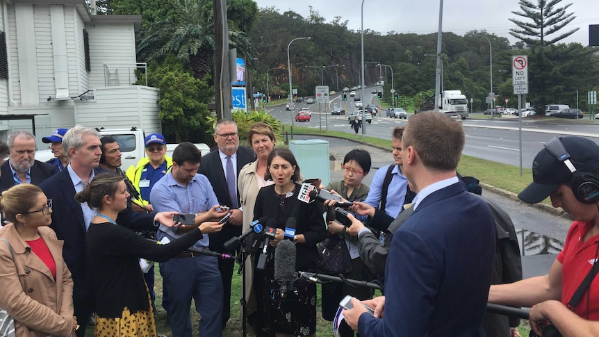 The Premier by a road in a throng of people and press.