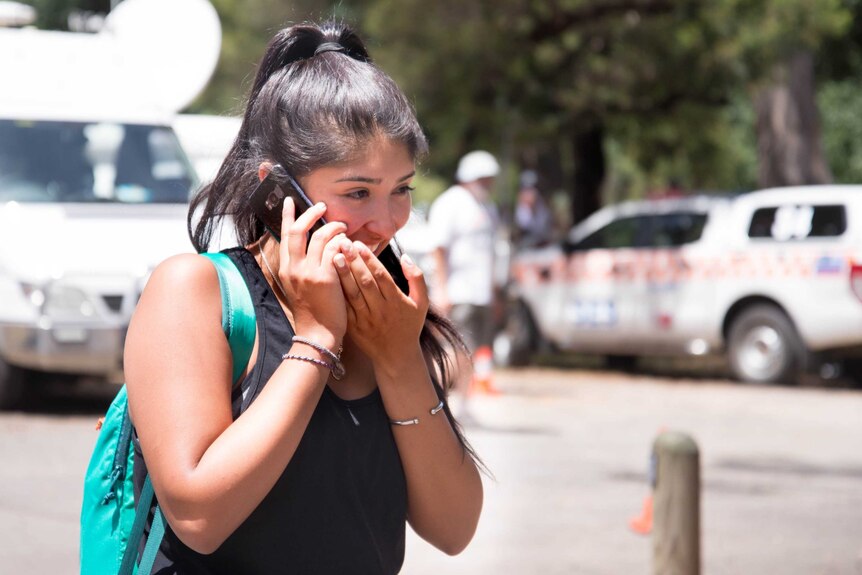 Julio Ascui's daughter, Jessica Ascui Ordonez, speaks on her phone after her father was found alive.