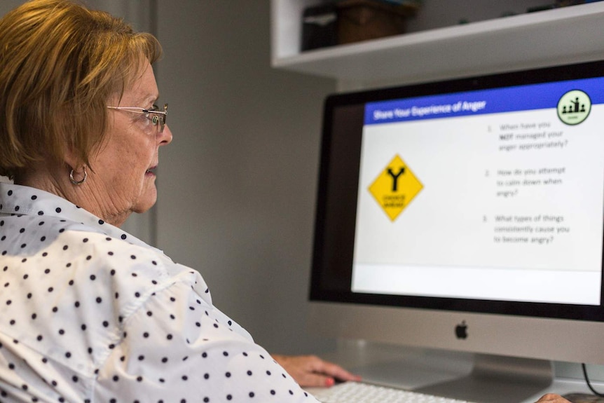 Denyse McKay sits at a computer.