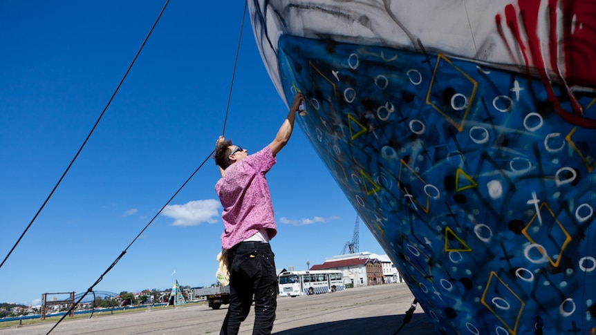 Street artist Anthony Lister at work on Sydney's Cockatoo Island as part of the Outpost street art festival.