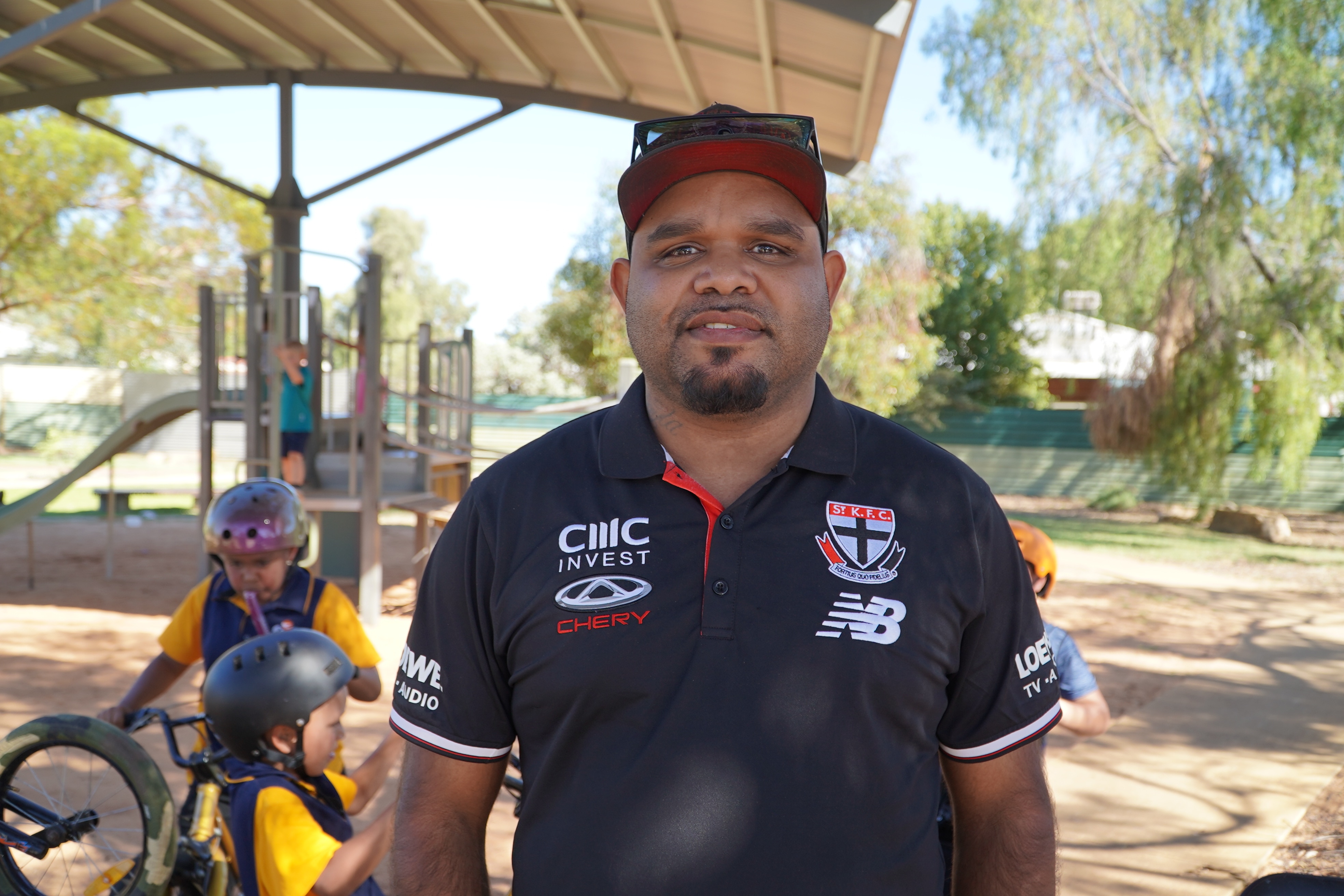 Un hombre indígena con una camiseta polo sonriendo a la cámara.