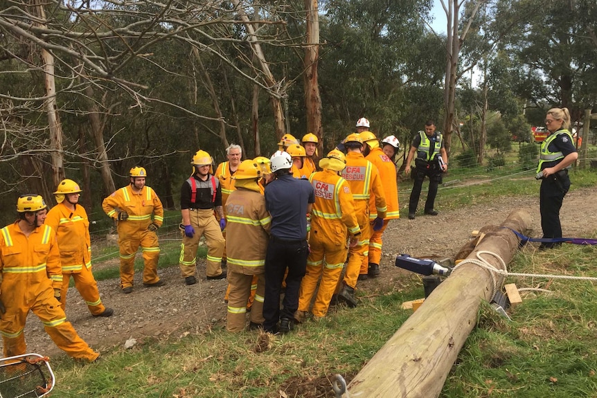 Rescue workers stretcher Odie Barwick from the scene, where he was trapped under a telegraph pole.