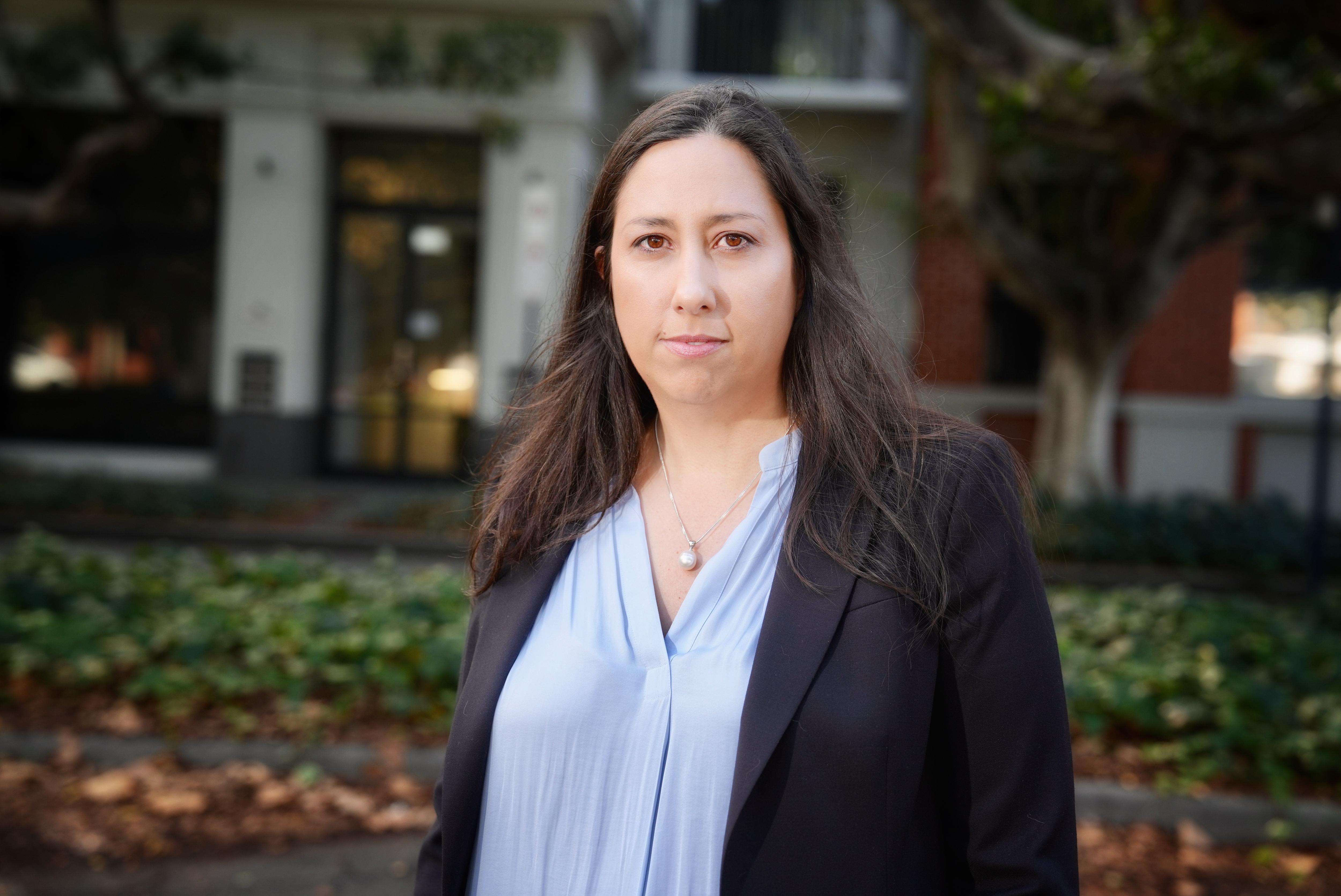A woman named Jolene Ellat stands outdoors looking serious.