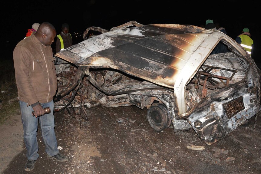 A man looks at the wreckage of a vehicle following an accident near Naivasha, Kenya.