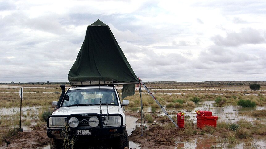Ian Andrews' four-wheel-drive in the desert, surrounded by floodwaters.