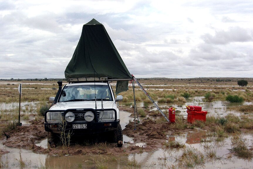 Ian Andrews' four-wheel-drive in the desert, surrounded by floodwaters.