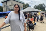 A woman poses in front of a building