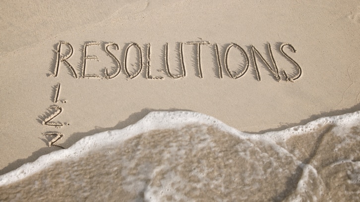 New Year Resolutions listed in the sand get wiped away by a swift wave