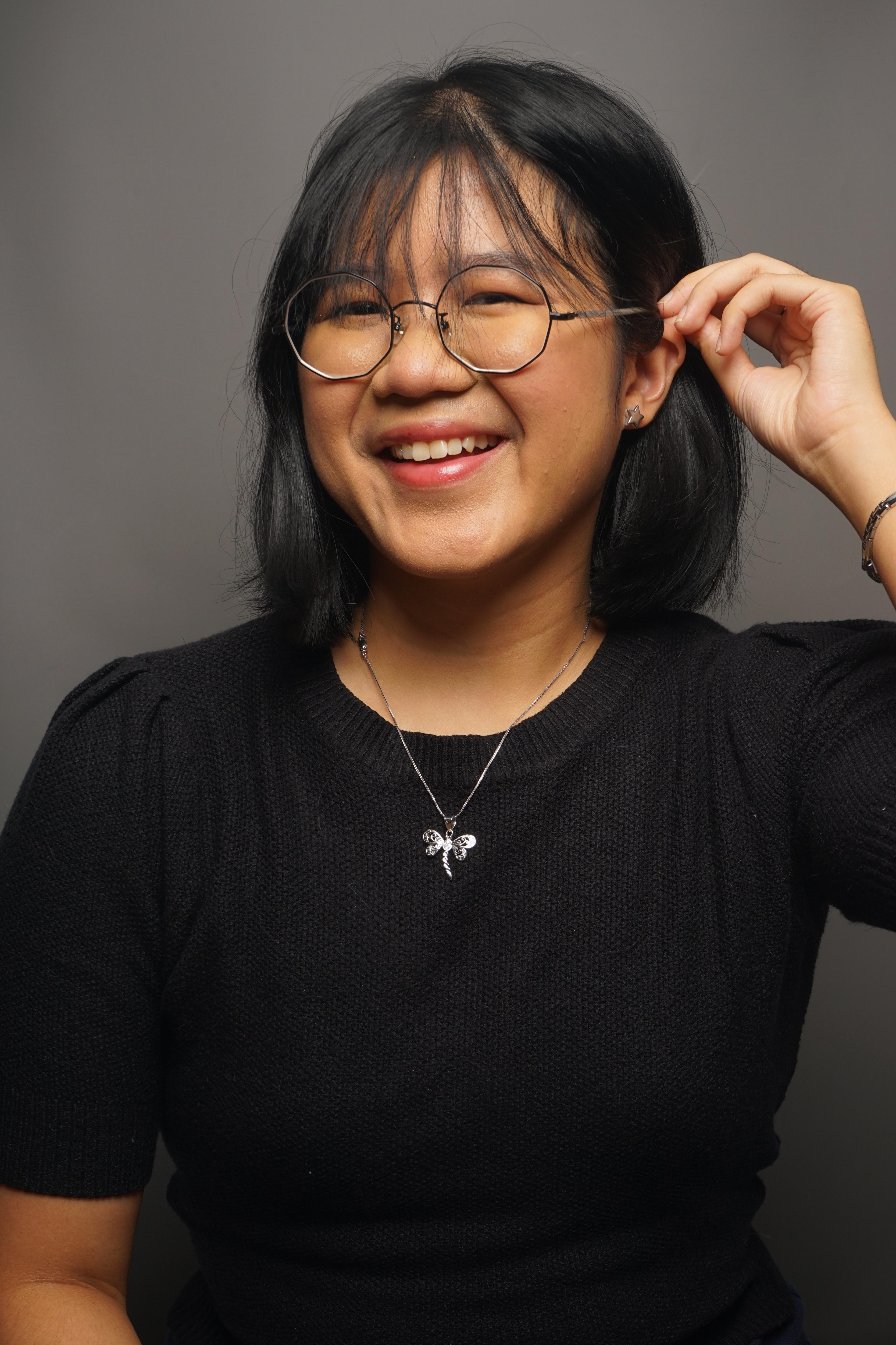 A woman wearing glasses and smiling to camera