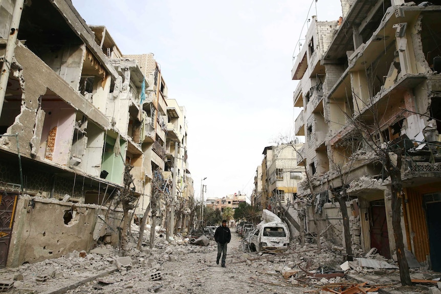 A man walks on a damaged street in the besieged town of Douma, eastern Ghouta.