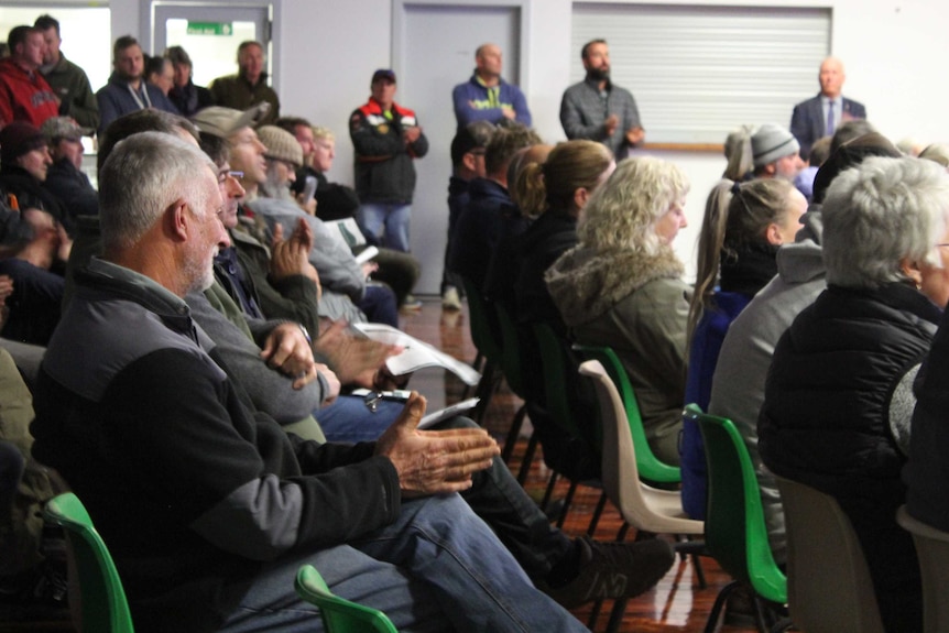 A group of people in a room at a deer hunting forum.