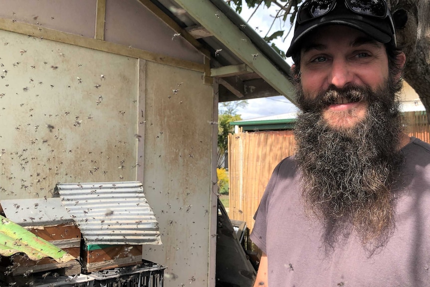 Beekeeper Kai Gerschau stands surrounded by flying native bees