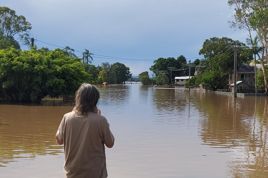 A young person looks out at the flooding in Coraki, northern NSW.