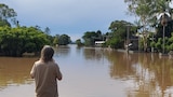 A young person looks out at the flooding in Coraki, northern NSW.