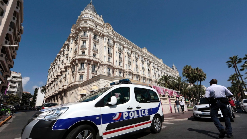 A police car is parked outside the Carlton Hotel in Cannes, after nearly $150 million worth of jewellery and watches were stolen
