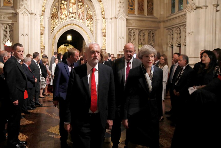 Theresa May and Jeremy Corbyn walk through the Peers Lobby.