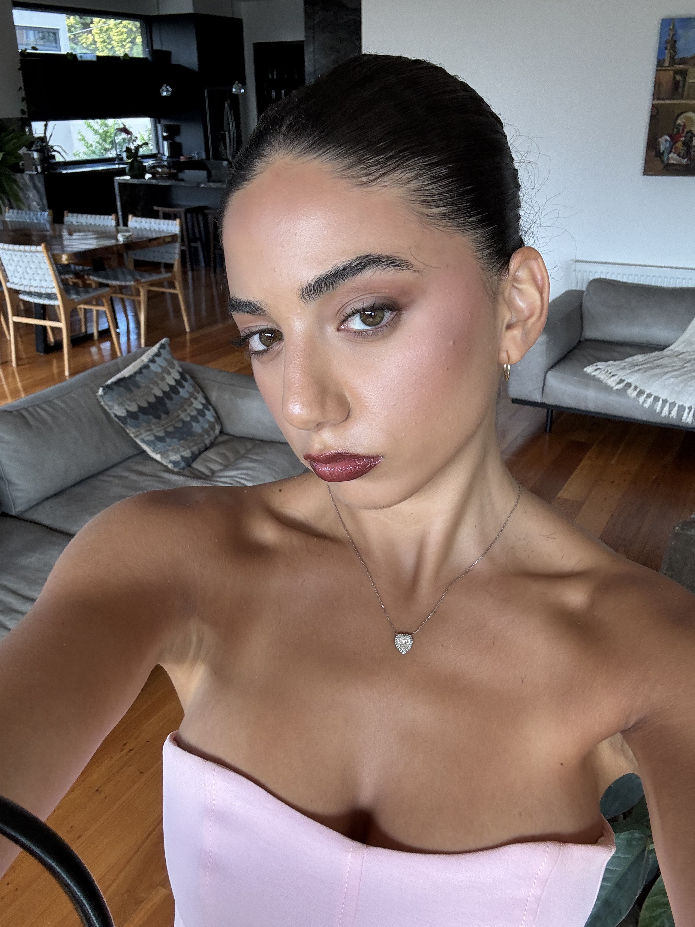 Uma jovem com uma blusa rosa tirando uma selfie.