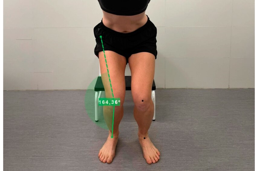 O ângulo do joelho é destacado nesta foto de uma mulher pousando com as pernas dobradas