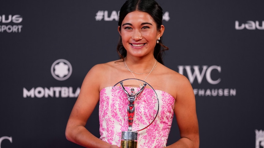 Arisa Trew holds her Laureus Sport Award while smiling for the cameras.