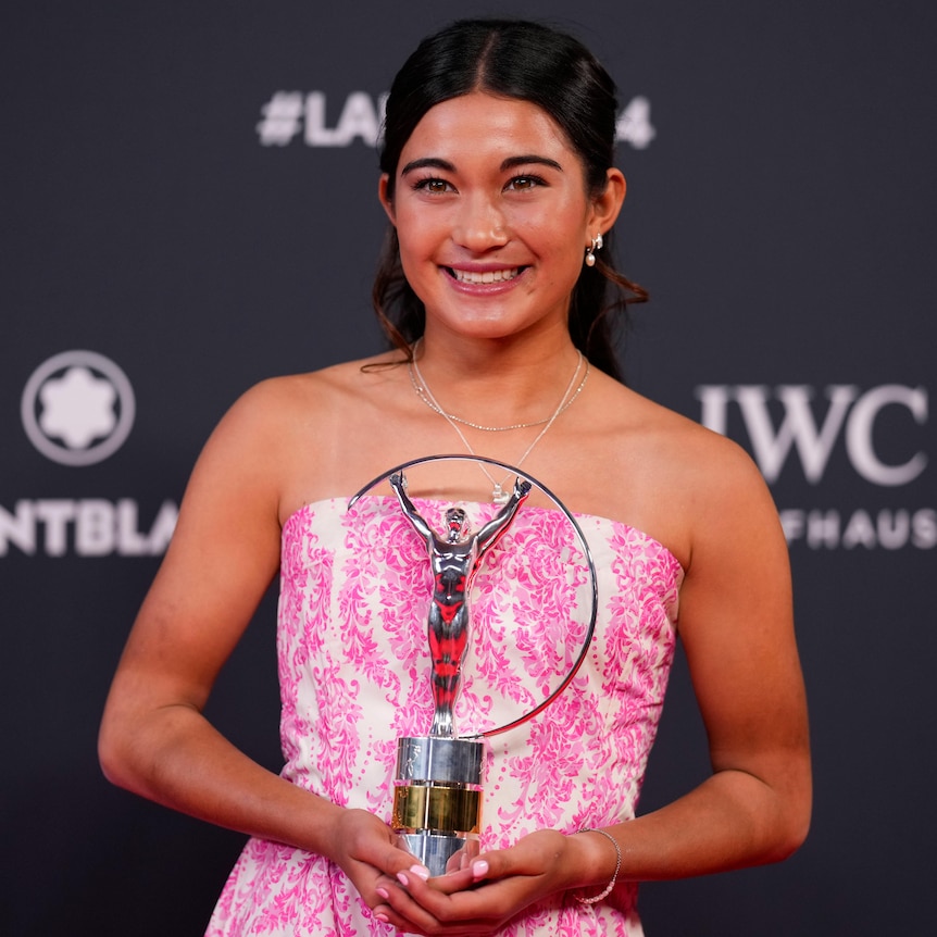 Arisa Trew holds her Laureus Sport Award while smiling for the cameras.