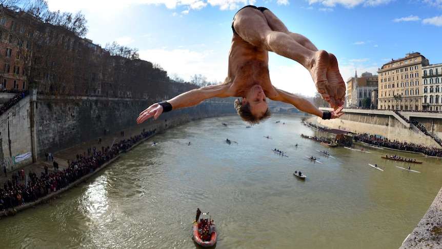 Marco Fois dives from the Cavour Bridge into the river Tiber.