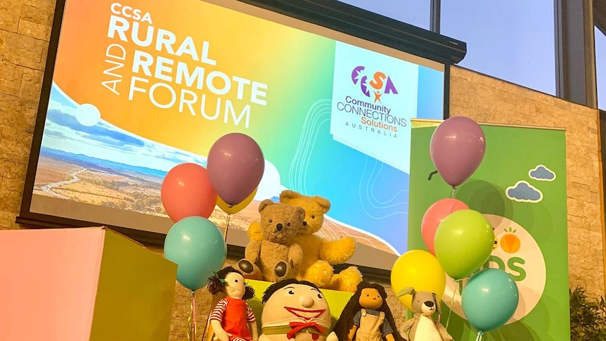 Play School toys with balloons in front of projection on wall for CCSA Rural and Remote forum