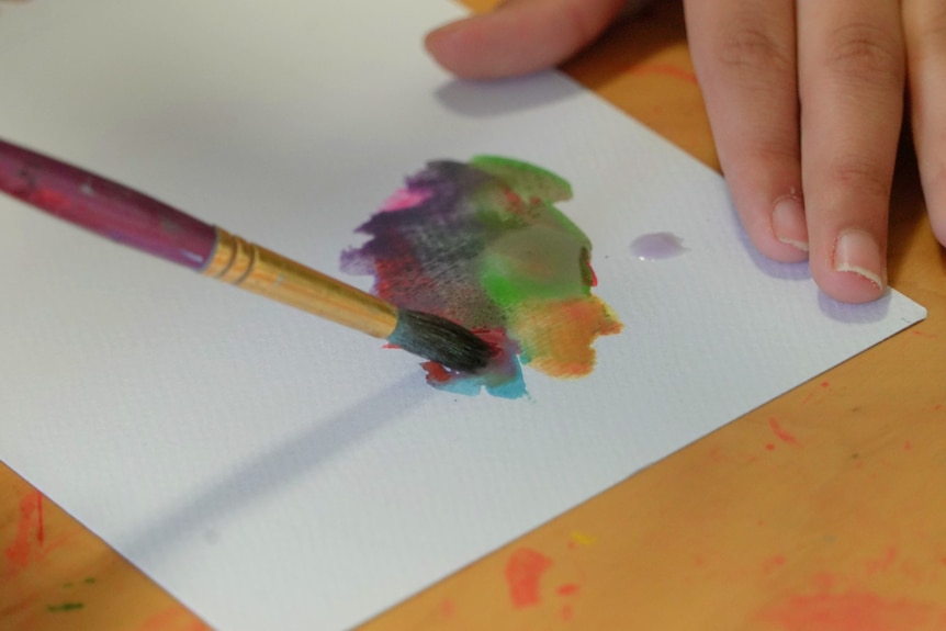 Close up of person painting in a healing art therapy session