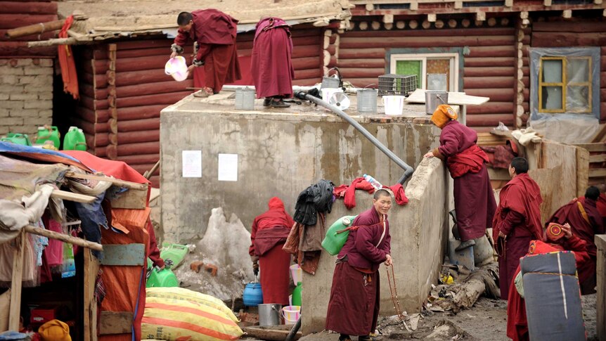 Apprentice Buddhist monks and nuns collect water at Seda Monastery.