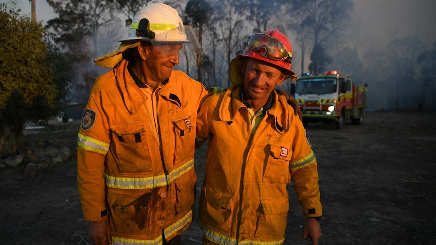 Two firefighters embrace.