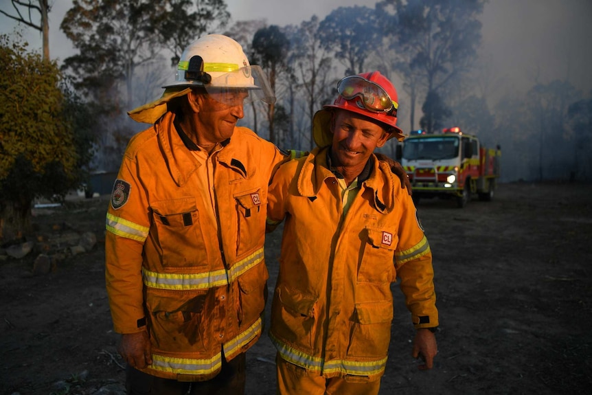 Two firefighters embrace.